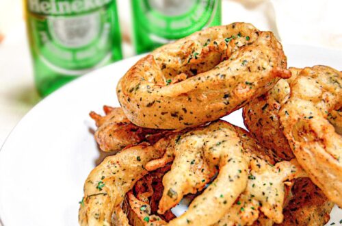 onion rings on a plate with chocolate coin and beer bottles in the background